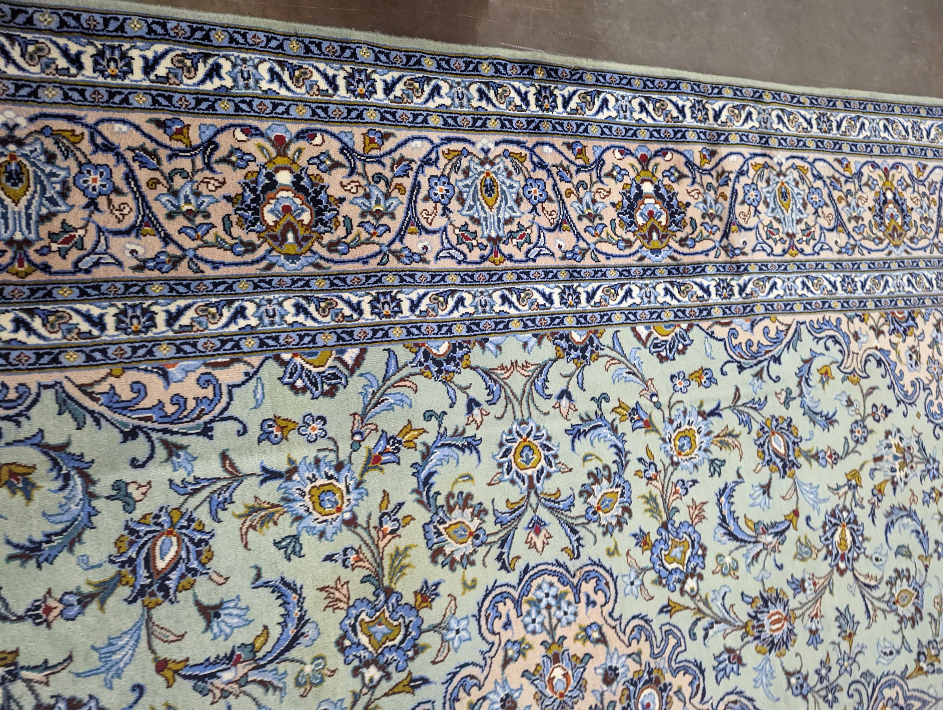 A Kashan pale green ground carpet, 410 x 296cm